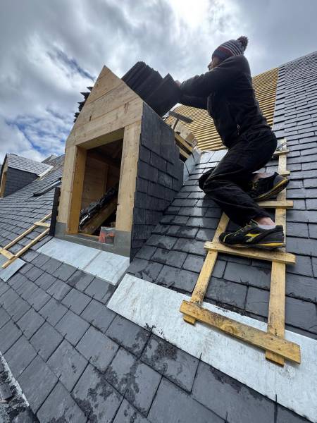 Pose de la couverture en ardoise en cour sur la lucarne par les 2 charpentiers, artisan RGE a Albi. 