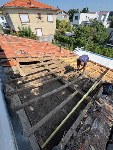 Démontage de la vielle tuile en cour avant la réfection totale de la toiture par les 2 charpentiers a Albi. 