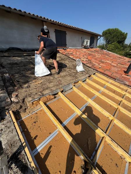 Dépose de la vielle couverture en tuile canal et nettoyage , avant la renovation complte de la toiture et la pose de l'isolation par les 2 charpentiers, artisan RGE a Albi. 