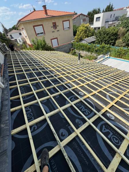 Mise en place des liteaux  pour le support de la couverture en tuile canal évolution par les 2 charpentiers, artisan RGE a Albi. 