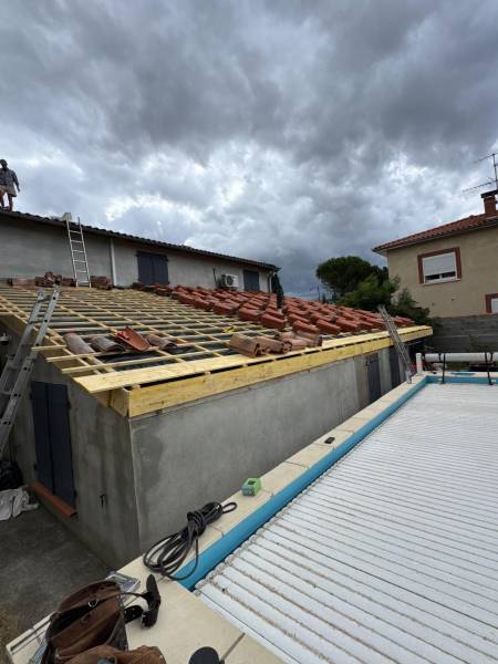 Pose en cour de réalisation de la noucvelle couverture en tuile canal évolution par les 2 charpentier artisan a Albi. 