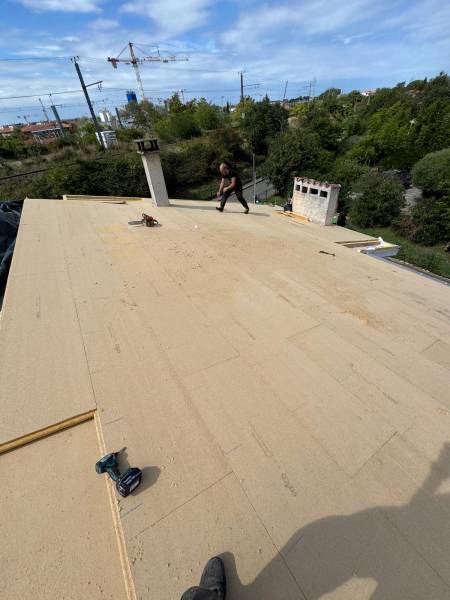 Pose de sarking en fibre de bois sur les chevron par les 2 charpentiers , artisan RGE a Albi. 