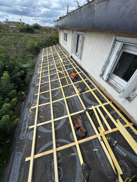 Pose d'un  ecran pare-pluie avant la pose de la couverture en tuile DC12 par les 2 charpentiers, société RGE a Albi.