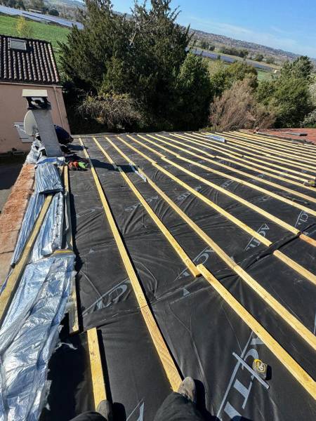 Réalisation en cours de la pose de l'isolant souple triso toiture de chez Actis, éligible au aides de l'état, par les 2 charpentiers.Artisan RGE a Albi. 