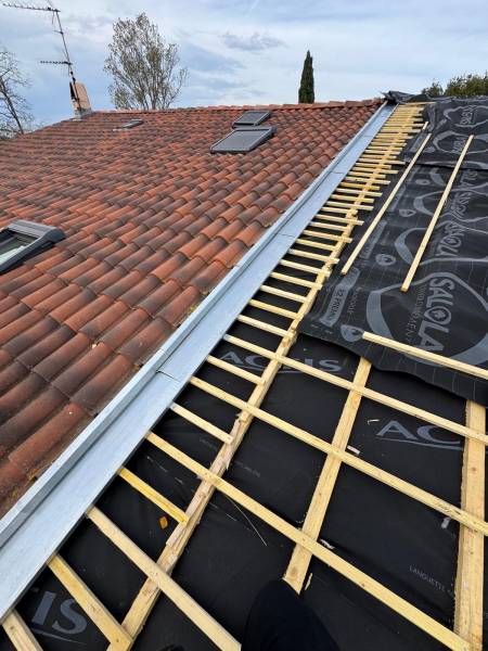 Raccord avec la toiture du voisin par un couloir en zinc sur mesure et pose d'un isolant souple sur la toiture par les 2 charpentiers, artisan RGE sur Albi et ses alentours. 